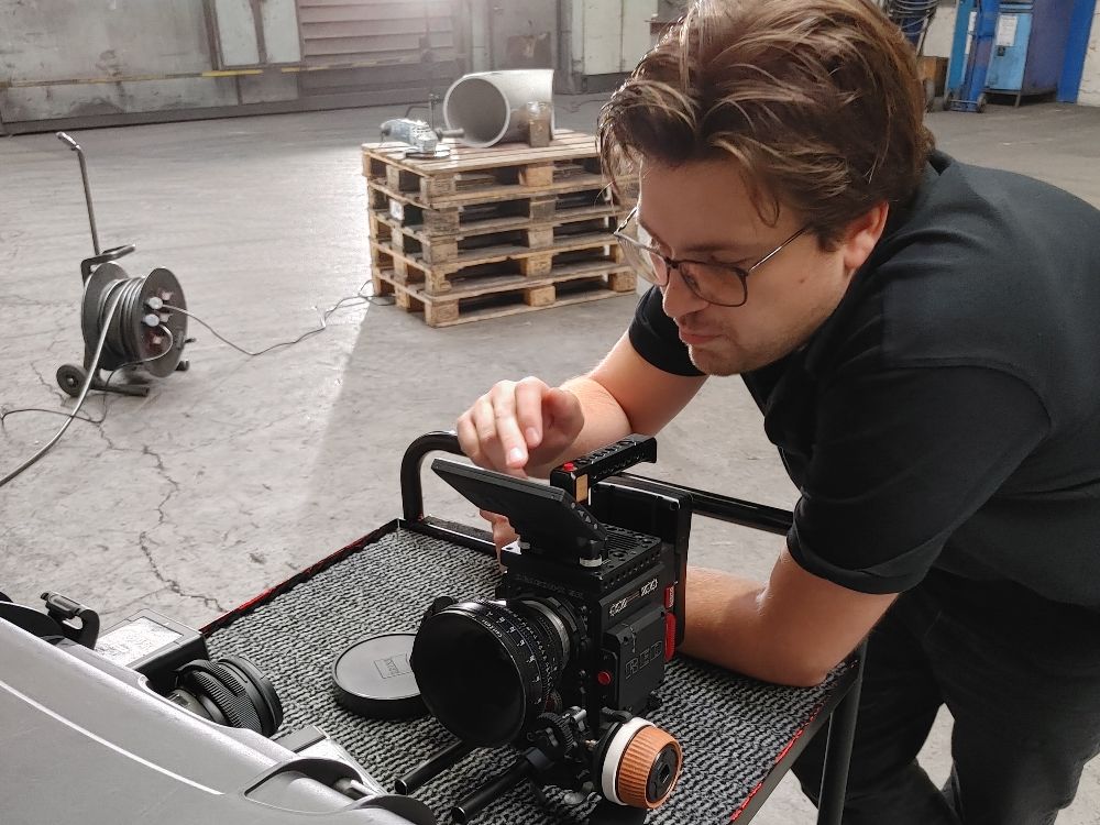 Jakob Mehrrath nimmt an einer professionellen Filmkamera einstellungen für die perfekte nächste Szene vor
